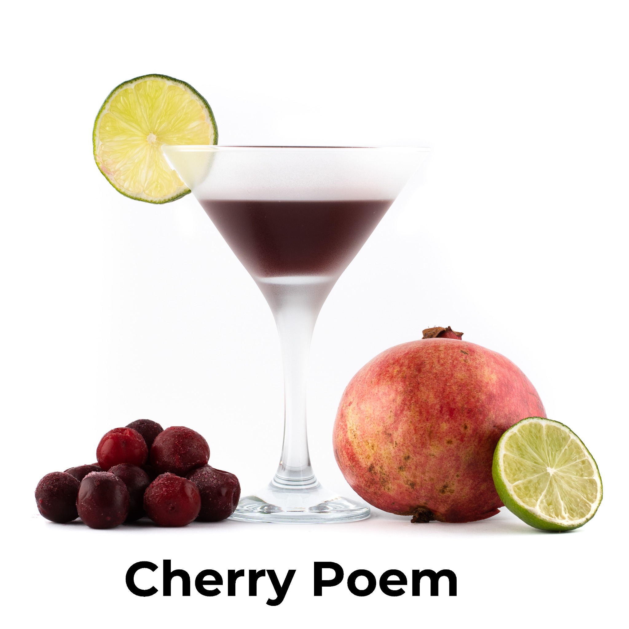 Martini z ciemnoczerwonym napojem, udekorowane plasterkiem limonki na krawędzi, obok leżą zamrożone wiśnie, granat i plasterek limonki na białym tle.