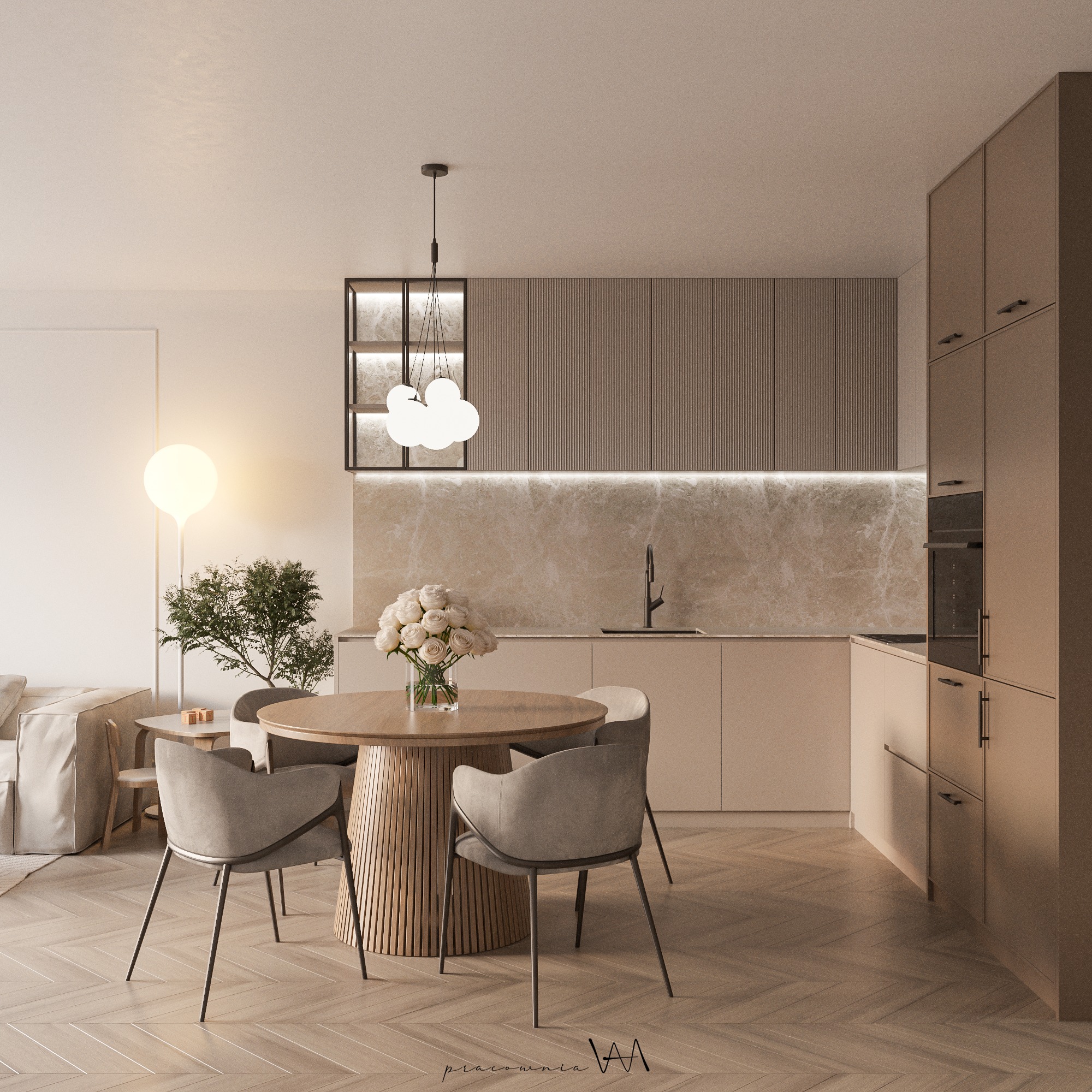 Beżowa kuchnia z okrągłym stołem z lamelami, kwiatami w wazonie i lampą w kształcie chmury, uzupełniona parkietem w jodełkę.