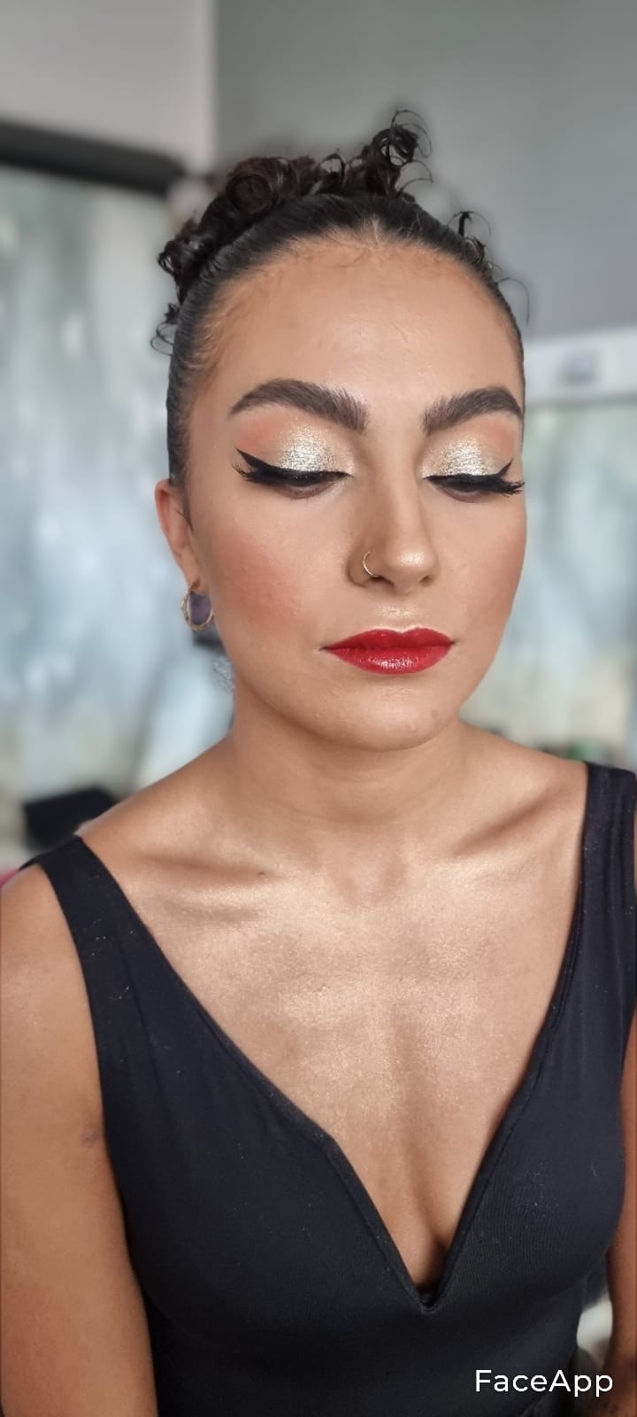 Portret kobiety z zamkniętymi oczami, prezentującej srebrzysty cień do powiek z czarnym eyelinerem, błyszczące czerwone usta i delikatny konturing twarzy.