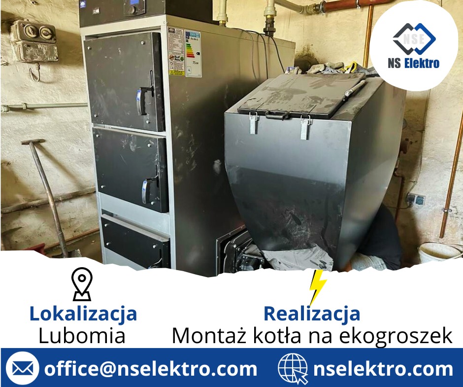 Montaż kotła na ekogroszek w kotłowni, widoczny zasobnik na paliwo, korpus kotła z drzwiczkami, instalacja rurowa na ścianie, obok ściany stoi łopata.