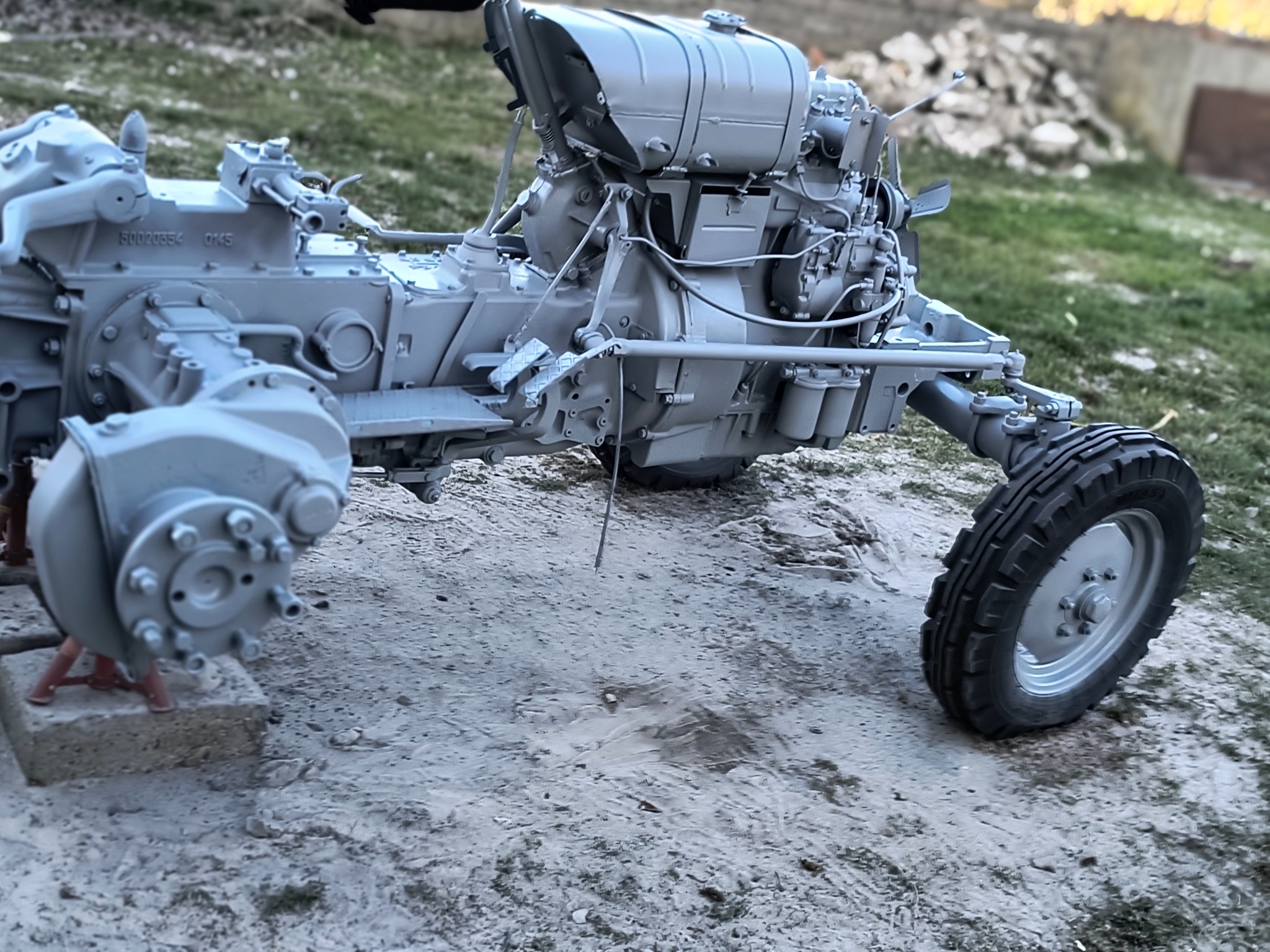 Odrestaurowany, szary traktor rolniczy na zewnątrz, po renowacji. Widoczne detale silnika, koła i konstrukcja. Renowacja z dbałością o szczegóły.