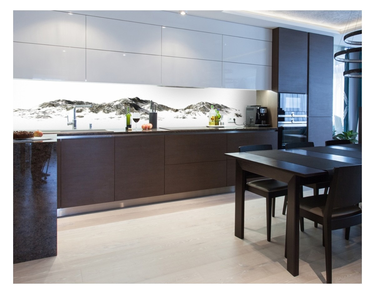 Szklany panel kuchenny z motywem górskim, zamontowany nad blatem, widoczny fragment stołu i krzeseł w nowoczesnej kuchni.