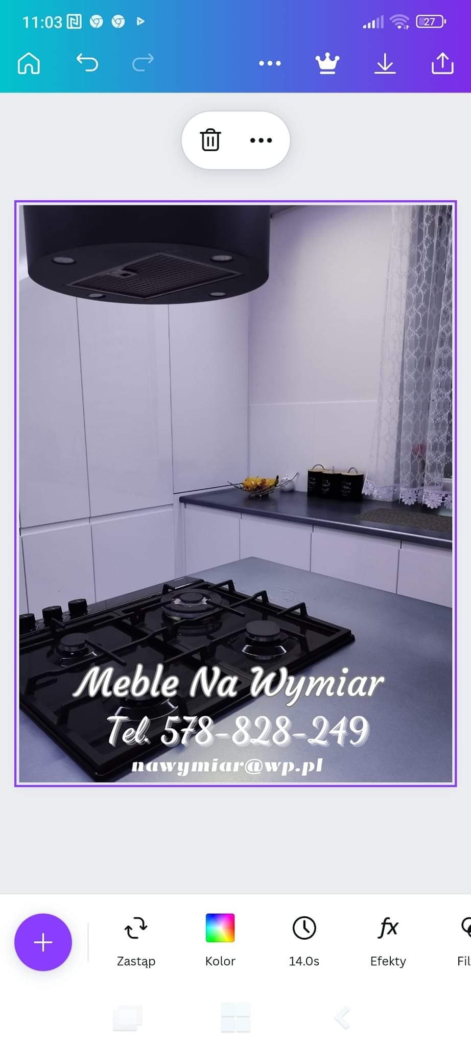 Częściowy widok nowoczesnej kuchni z białymi szafkami, czarnym blatem i płytą gazową; na blacie dekoracyjna misa z owocami, nad blatem okrągły, czarny okap; na pierwszym planie płyta gazowa...