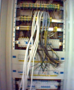 Rozdzielnica elektryczna z widocznymi przewodami w trakcie podłączania, z bliska, oświetlenie sztuczne.