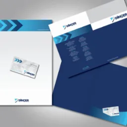 Komplet materiałów firmowych: papier firmowy, wizytówka i teczka z logo Dincer, utrzymane w kolorystyce bieli i granatu z motywem strzałek.