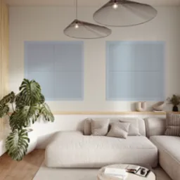 Minimalistyczny salon z panelami ściennymi o wzorze ukośnych linii, kremową sofą i drewnianą podłogą, oświetlony wiszącymi lampami o ażurowych kloszach.