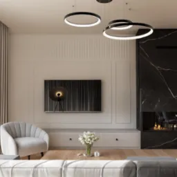 Elegancki salon w Dziewinie z kominkiem z czarnego marmuru, okrągłymi lampami sufitowymi, szarą sofą i fotelem oraz telewizorem z abstrakcyjnym obrazem.