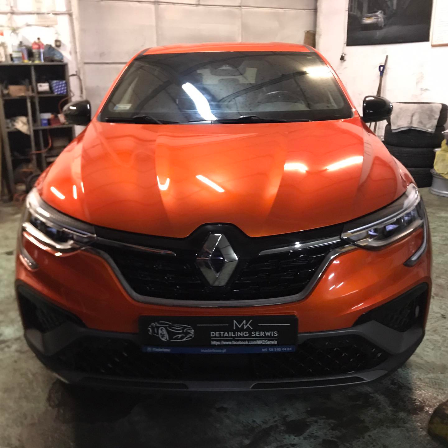 Pomarańczowy Renault Arkana RS po detailingu, widok z przodu na błyszczący lakier i logo MK Detailing Serwis na tabliczce.