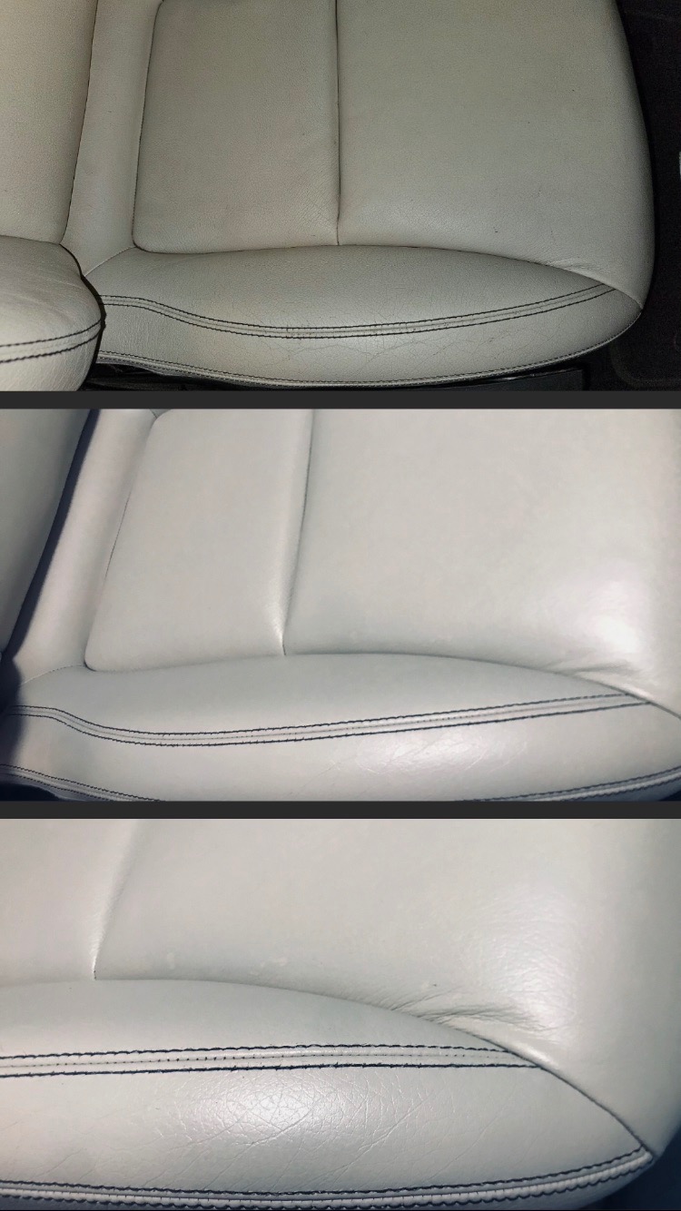 Fragment jasnej, skórzanej tapicerki samochodowej z widocznymi przeszyciami, ukazujący zużycie i lekkie zabrudzenia na powierzchni.