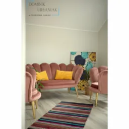 Salon w pastelowych kolorach: różowa sofa w stylu retro z żółtymi poduszkami, dwa fotele i dywan w paski na jasnej podłodze. W tle dekoracja ścienna z motywem kwiatowym i roślina w plecionym koszu.