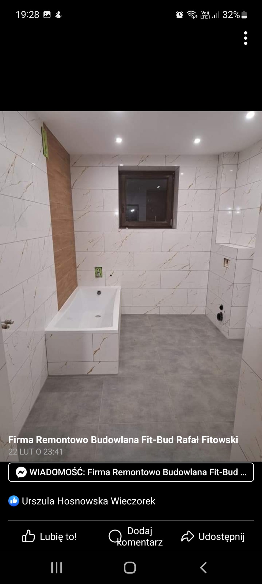 Wnętrze łazienki po remoncie w Raciborzu: białe płytki imitujące marmur na ścianach, szare płytki podłogowe, wanna obudowana płytkami, okno z brązową ramą, widoczne punkty instalacji.