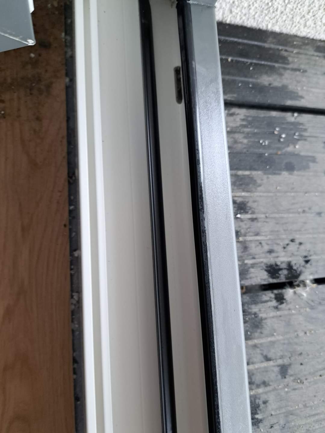 Szczegółowe ujęcie ramy okiennej z uszczelkami, widoczne zabrudzenia i pozostałości po uszczelnianiu, ukazujące potrzebę dokładnego oczyszczenia.