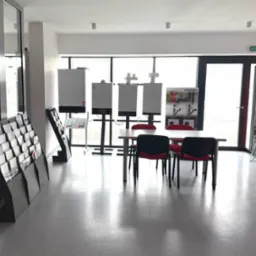 Wnętrze salonu ekspozycyjnego z trzema modelami kotłów gazowych Viessmann na stojakach, stolikiem z krzesłami oraz stojakami z broszurami informacyjnymi w jasnym, nowoczesnym pomieszczeniu.