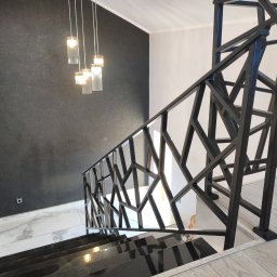 Balustrady, konstrukcje Bydgoszcz i okolice WBO Bartosz Winowiecki - Nowoczesne schody z czarną, geometryczną balustradą metalową. Widok z góry, marmurowe stopnie, designerskie lampy wiszące, ściana z fakturą.