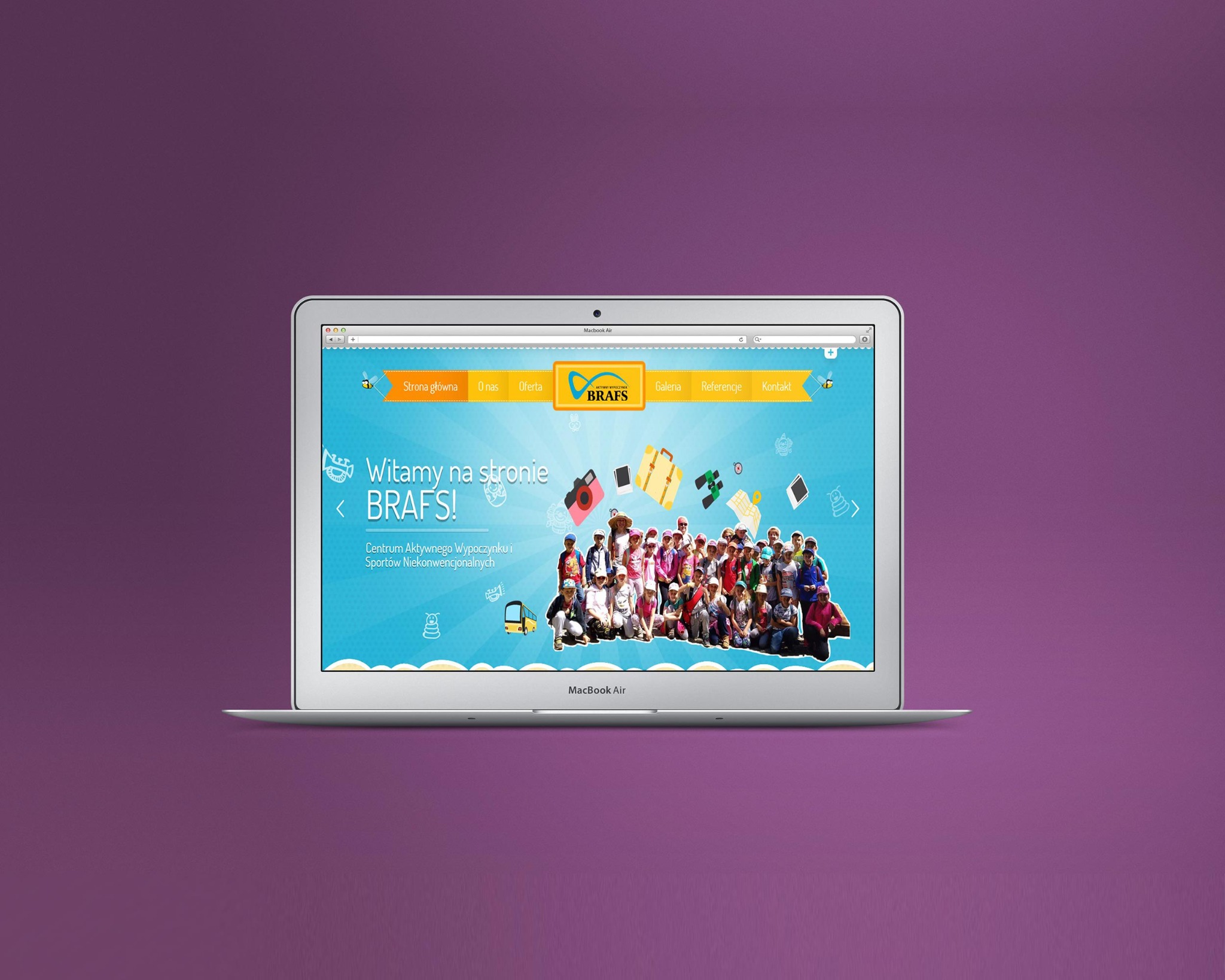 Laptop Macbook Air wyświetla stronę internetową z niebieskim tłem, logiem BRAFS, menu nawigacyjnym i zdjęciem grupowym dzieci.