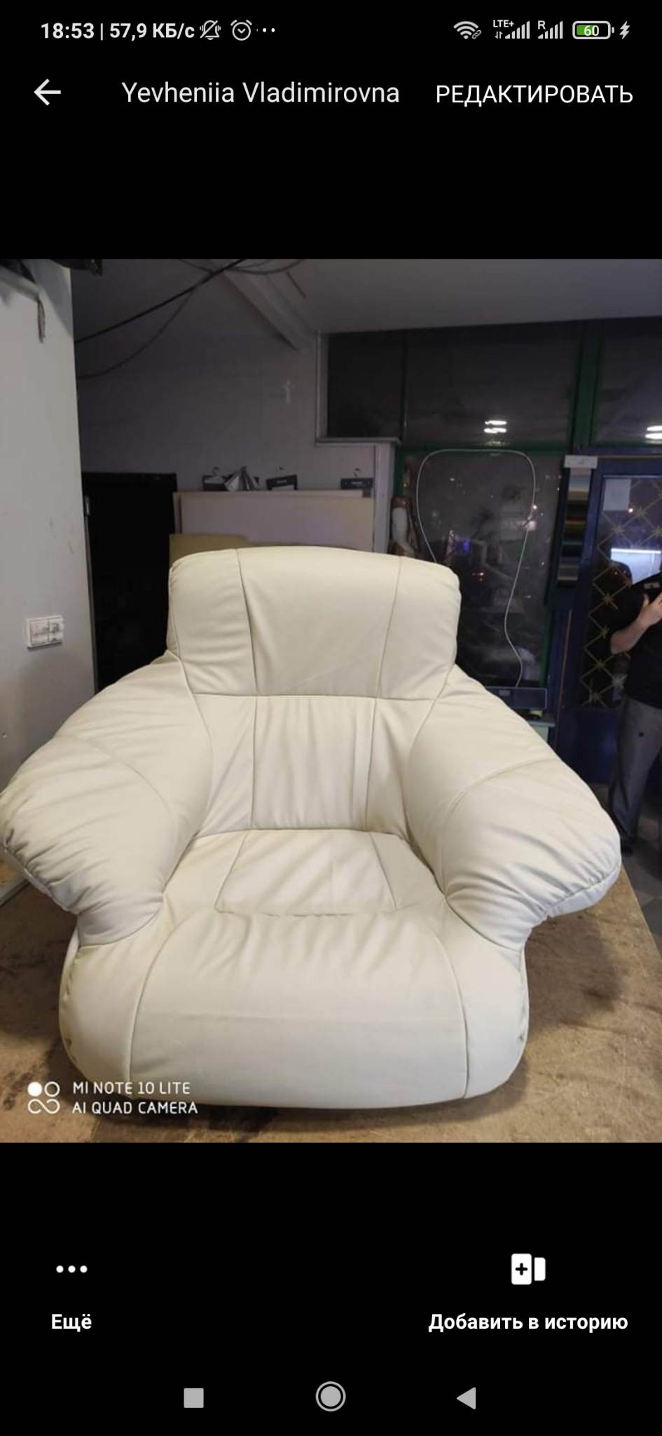 Beżowy, skórzany fotel klubowy z szerokimi podłokietnikami, sfotografowany w warsztacie na drewnianym stole.