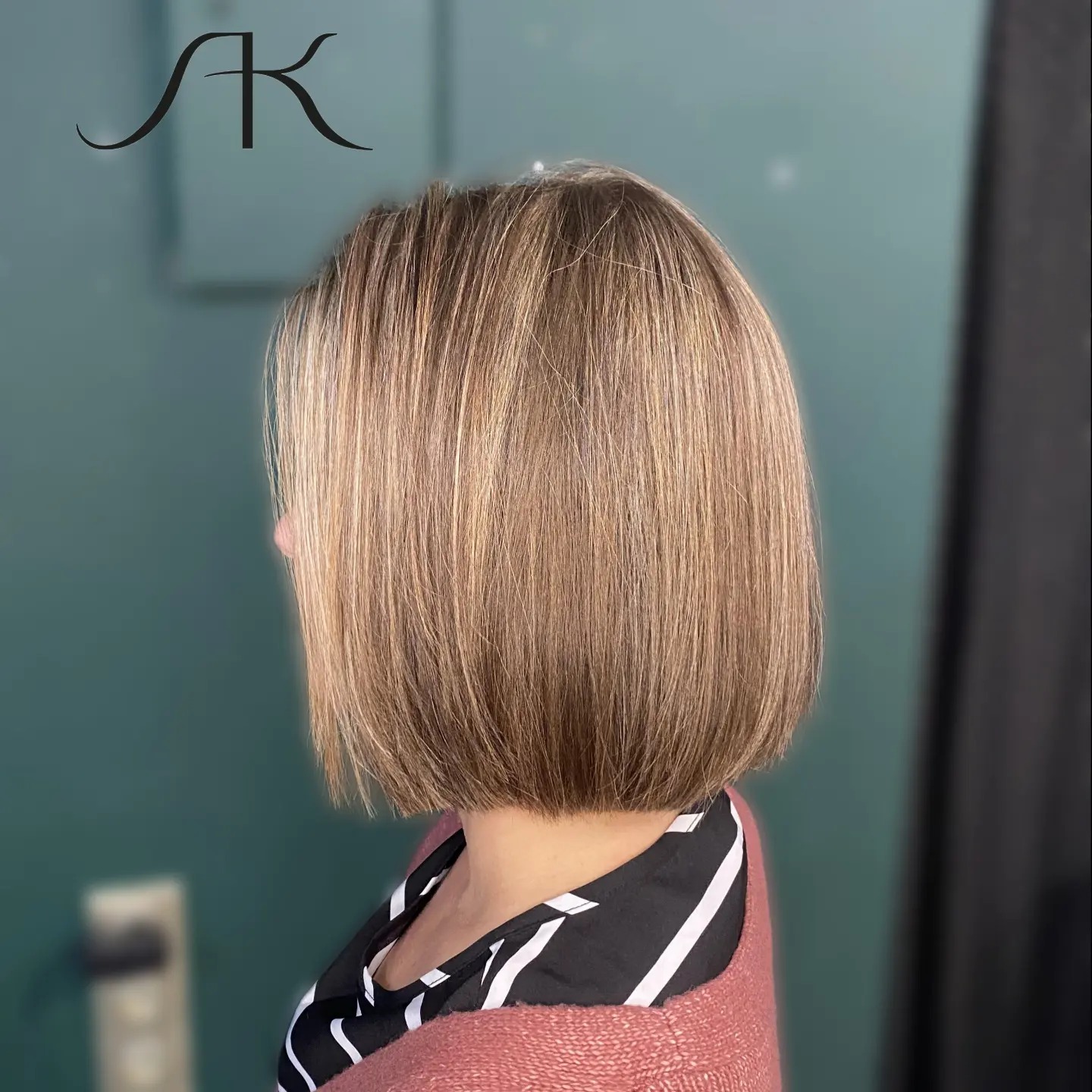 Blond bob z delikatnymi refleksami, widok z boku, na zielonym tle, z logo w lewym górnym rogu.