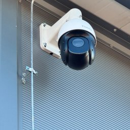 ITCAM Rafał Iwańczyk - Zewnętrzna kamera obrotowa Tiandy, zamontowana na ścianie z blachy trapezowej, zabezpieczona kablem w metalowej rurce.