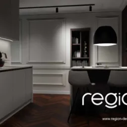 Elegancka kuchnia z wyspą i krzesłami barowymi w stylu retro, oświetlona lampą wiszącą, z ciemną drewnianą podłogą i dekoracyjnymi listwami ściennymi.