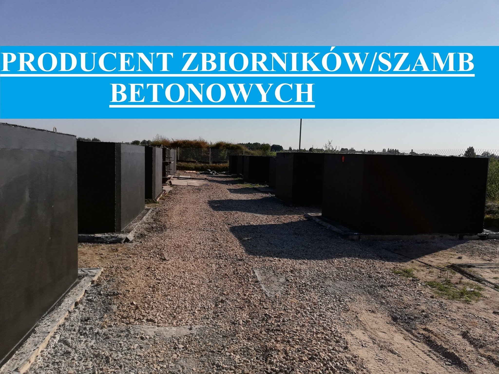 Rząd czarnych, betonowych zbiorników ustawionych na żwirowym podłożu, z błękitnym napisem 'PRODUCENT ZBIORNIKÓW/SZAMB BETONOWYCH' u góry.
