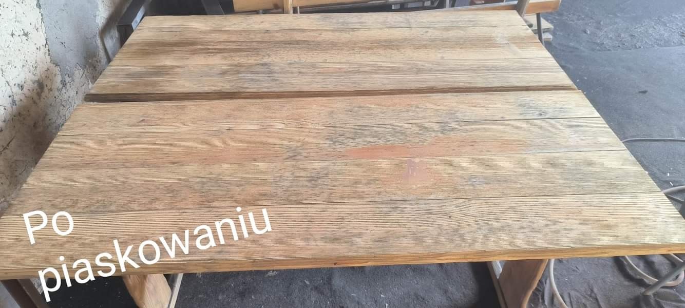 Blat drewnianego stołu po piaskowaniu, ukazujący odświeżoną strukturę drewna z widocznymi słojami i subtelnymi przebarwieniami.