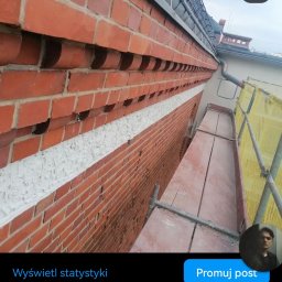 Krzysia Kaczmarek - Ceglana elewacja budynku z widoczną warstwą szpachli na łączeniu, ujęcie z rusztowania.