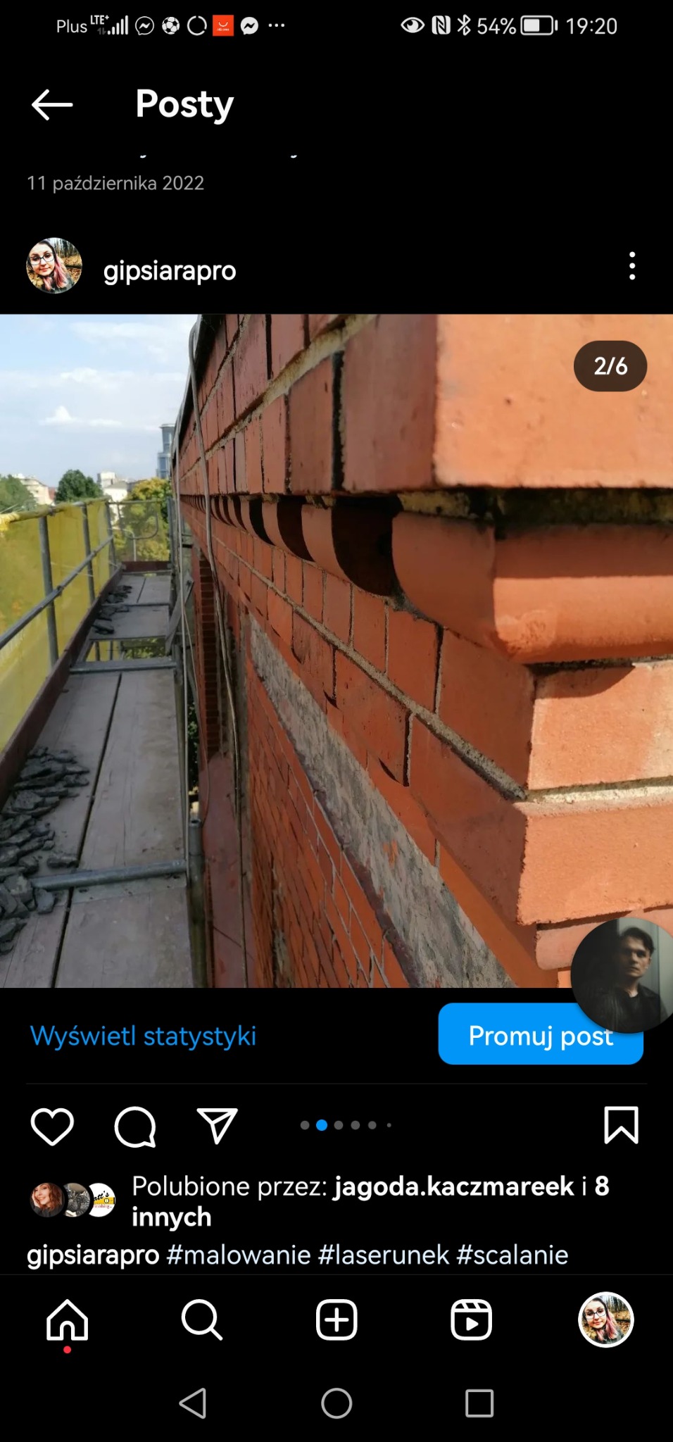 Ceglana elewacja budynku w trakcie renowacji, widoczne rusztowanie i częściowo wyczyszczone spoiny między cegłami.