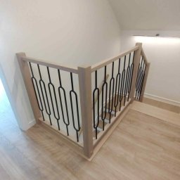 MARWOOD - Drewniana balustrada schodowa z czarnymi, metalowymi prętami na jasnych schodach. Nowoczesny design, widok z góry.