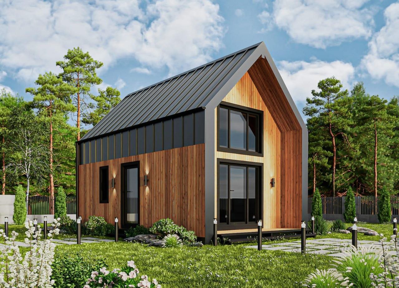 Nowoczesny dom szkieletowy z drewnianą elewacją i metalowym dachem na tle zieleni, oświetlony lampami ogrodowymi.