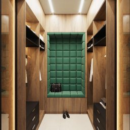 Inargo - Wnętrze garderoby z drewnianymi szafami, szklanymi drzwiami i zieloną, pikowaną wnęką z siedziskiem, oświetlonymi półkami oraz kolekcją butów i ubrań.