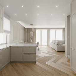 Inargo - Jasna kuchnia w otwartym planie z drewnianą podłogą w jodełkę, widok na salon z sofą w tle, minimalistyczny design.