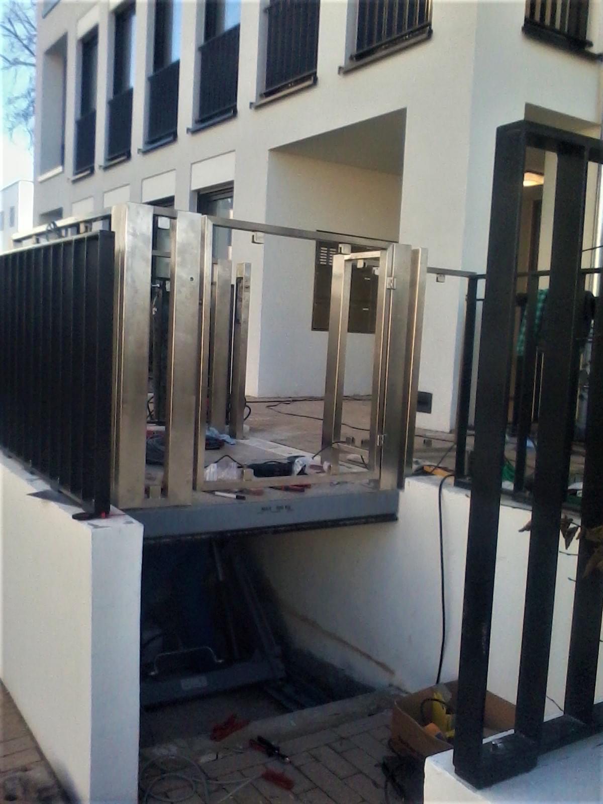 Montaż balustrady ze stali nierdzewnej na balkonie budynku wielorodzinnego, widoczne narzędzia i materiały montażowe.