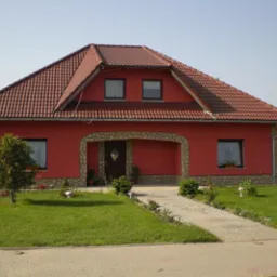 Czerwony dom jednorodzinny z brązową dachówką, kamiennym wykończeniem wokół wejścia i okien, oraz zadbanym trawnikiem.