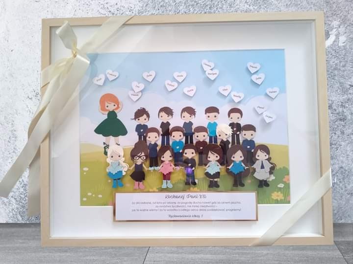Oprawiona w ramkę papierowa grafika przedstawiająca grupę dzieci i nauczycielkę z imionami w sercach na tle nieba, prezent dla nauczyciela.