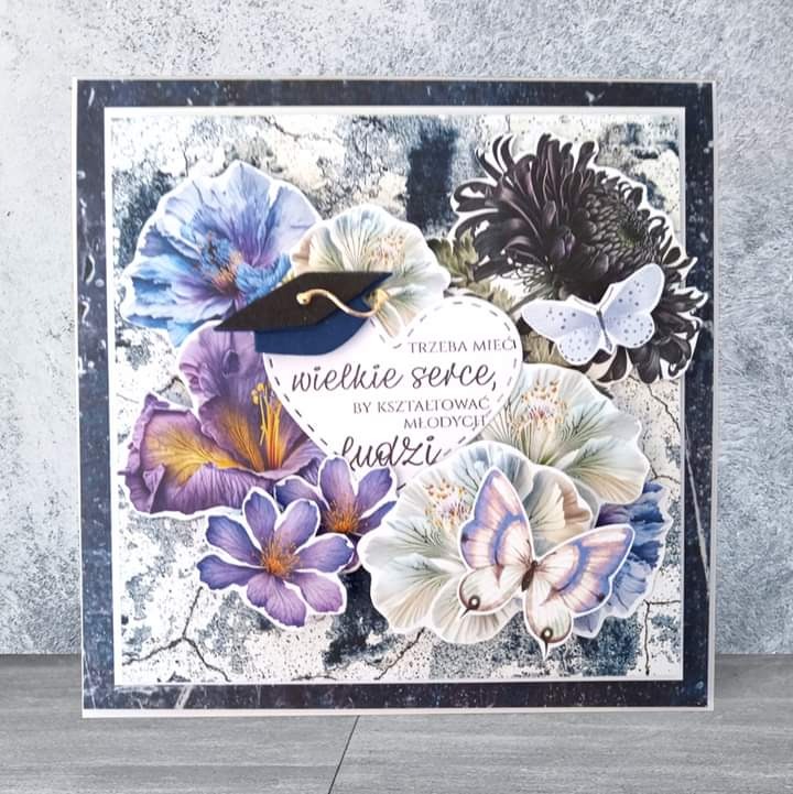 Ręcznie robiona kartka okolicznościowa z kwiatami, motylami i napisem 'Trzeba mieć wielkie serce, by kształtować młodych ludzi' oraz miniaturową czapką absolwenta.