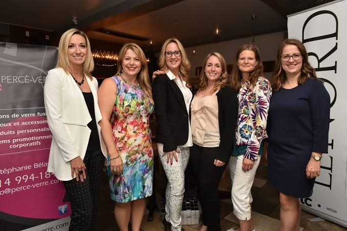 Grupa pięciu uśmiechniętych kobiet pozuje na tle ściany z logo firmy Perce-Verre, specjalizującej się w wyrobach ze szkła artystycznego i upominkach firmowych.