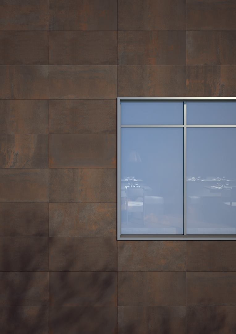 Elewacja budynku wykończona brązowymi płytami imitującymi rdzę, z widocznym oknem przesuwnym z aluminiową ramą i odbiciem wnętrza restauracji.