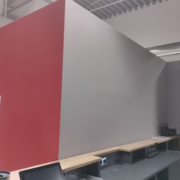 Firma budowlana WBR - Świeżo pomalowane, dwukolorowe ściany w biurze, widok zza biurka z monitorem i drukarką, sufit z blachy trapezowej.