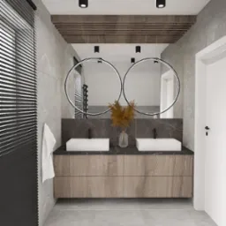 Nowoczesna łazienka w Koszalinie z dwoma białymi umywalkami nablatowymi na drewnianej szafce, okrągłe lustra podświetlane LED i szara marmurowa ściana.