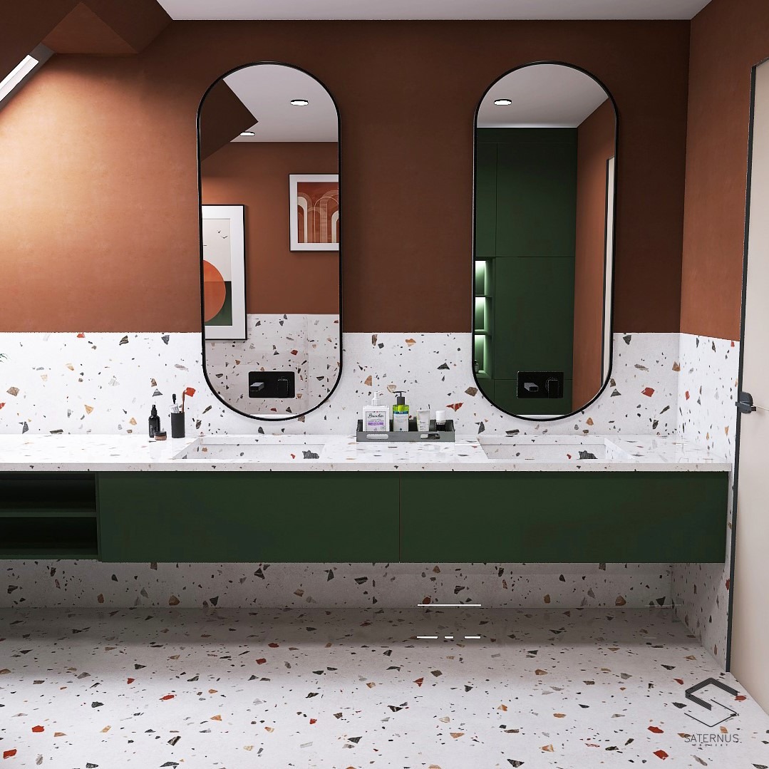 Nowoczesna łazienka z dwoma owalnymi lustrami, blatem i podłogą wykończonymi w stylu terrazzo, zielonymi szafkami pod umywalkami i brązowymi ścianami.