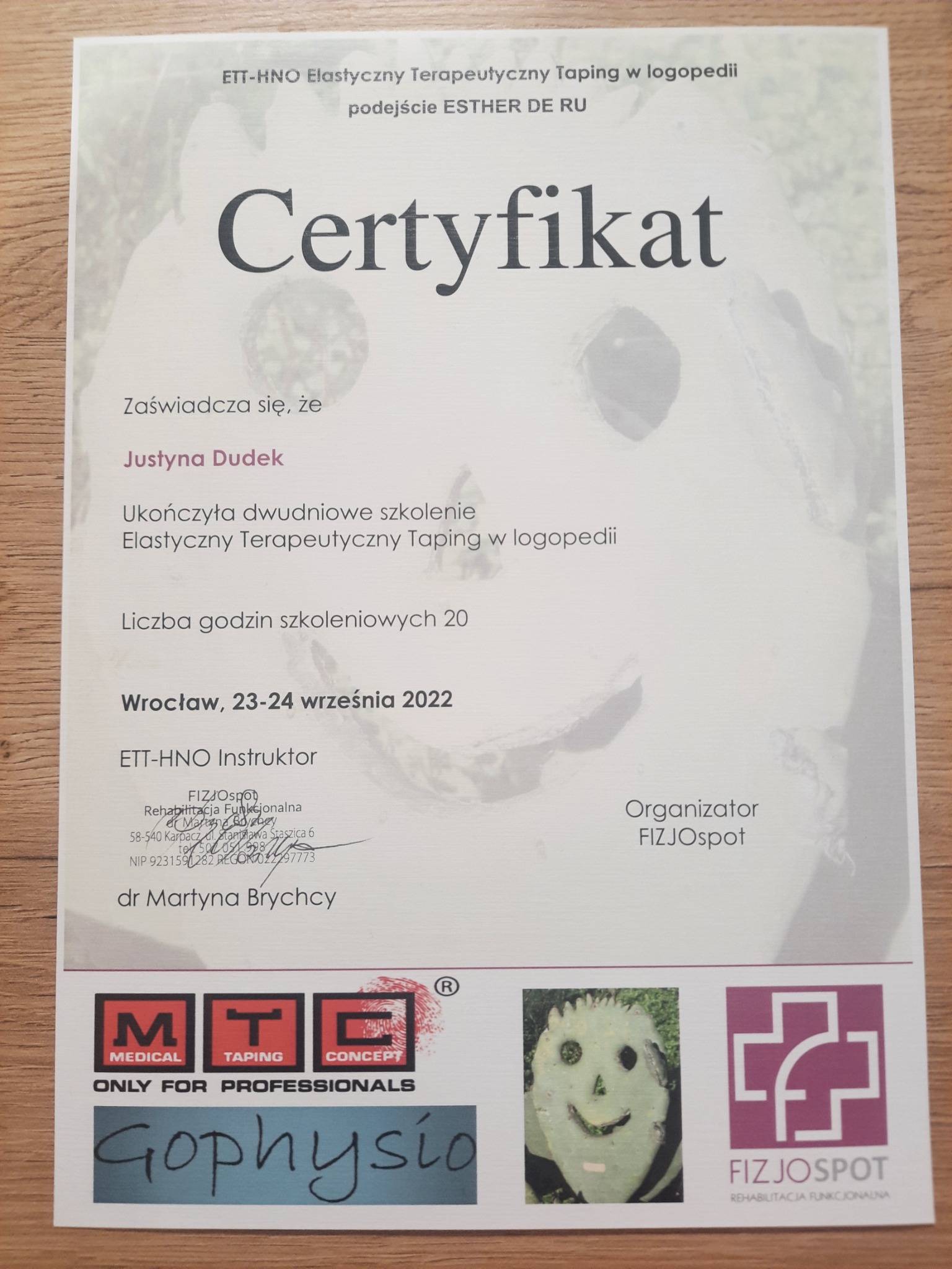 Certyfikat ukończenia szkolenia z elastycznego terapeutycznego tapingu w logopedii dla Justyny Dudek, wydany we Wrocławiu w 2022 roku, z logotypami organizatorów i instruktora.
