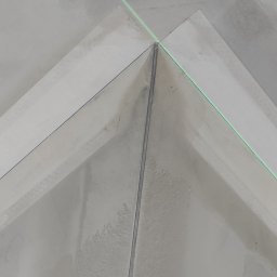 Regimex licencjonowany wykonawca firmy RIGIPS Polska. - Kąt wewnętrzny sufitu z zamontowaną płytą, widoczna linia lasera wyznaczająca poziom, ślady szpachlowania na powierzchni.