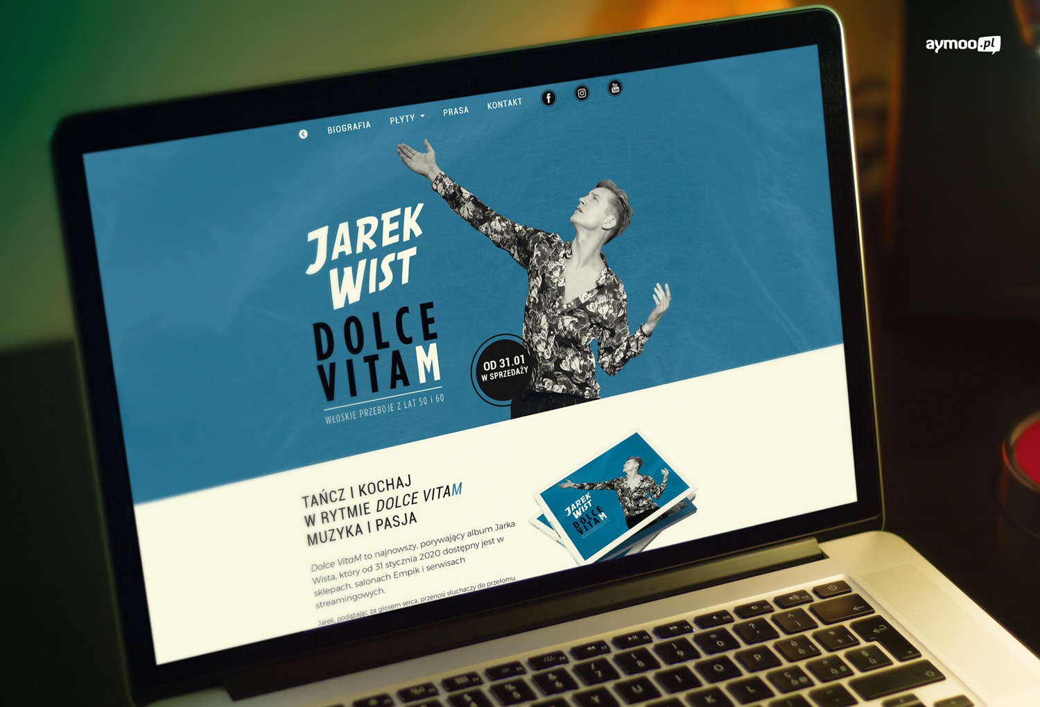 Ekran laptopa wyświetlający stronę internetową Jarka Wista promującą album Dolce Vitam, widoczny kadr strony z artystą w rozłożonych rękach i okładka albumu