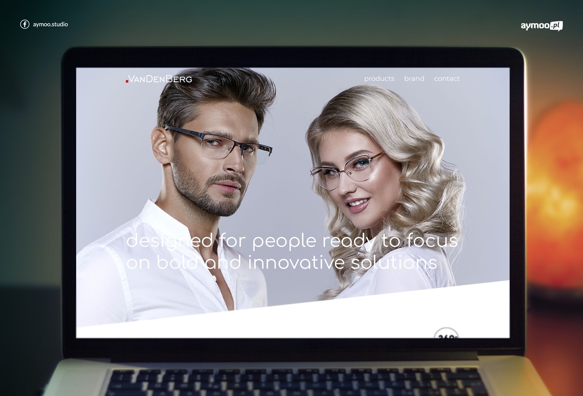 Ekran laptopa wyświetlający stronę internetową firmy VanDenBerg z wizerunkiem modela i modelki w okularach, prezentacja strony w warunkach studyjnych.