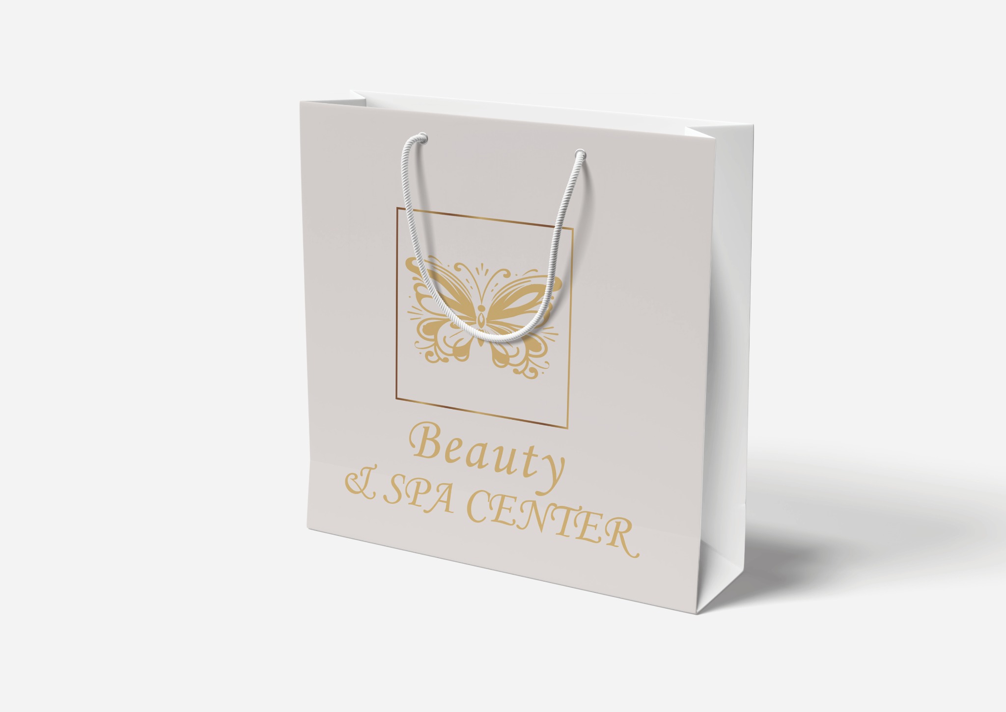 Biała torba papierowa z nadrukowanym złotym logo motyla w ramce i napisem 'Beauty & SPA CENTER'.