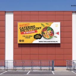 BR Studio Graficzne Barbara Rutkowska - Reklama zewnętrzna catering dietetyczny na elewacji budynku, widoczne dwa banery z logo firmy, zdjęciem posiłku i hasłem reklamowym.