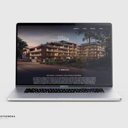 BR Studio Graficzne Barbara Rutkowska - Laptop MacBook Pro wyświetlający wizualizację architektoniczną nowoczesnego budynku mieszkalnego z balkonami, zieleń wokół, na stronie internetowej studia graficznego Barbara Rutkowska.