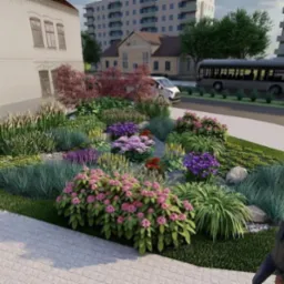 Wizualizacja ronda z bogato ukwieconym klombem, obejmującym różnorodne gatunki roślin, kamienie ozdobne i trawnik, na tle budynku, ulicy z autobusem i bloku mieszkalnego.