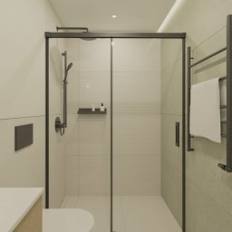 Poligon Design Tomasz Ciurka - Nowoczesna łazienka z kabiną prysznicową w czarnej ramie, grzejnikiem drabinkowym i beżowymi płytkami. Minimalistyczny wystrój z drewnianymi akcentami.