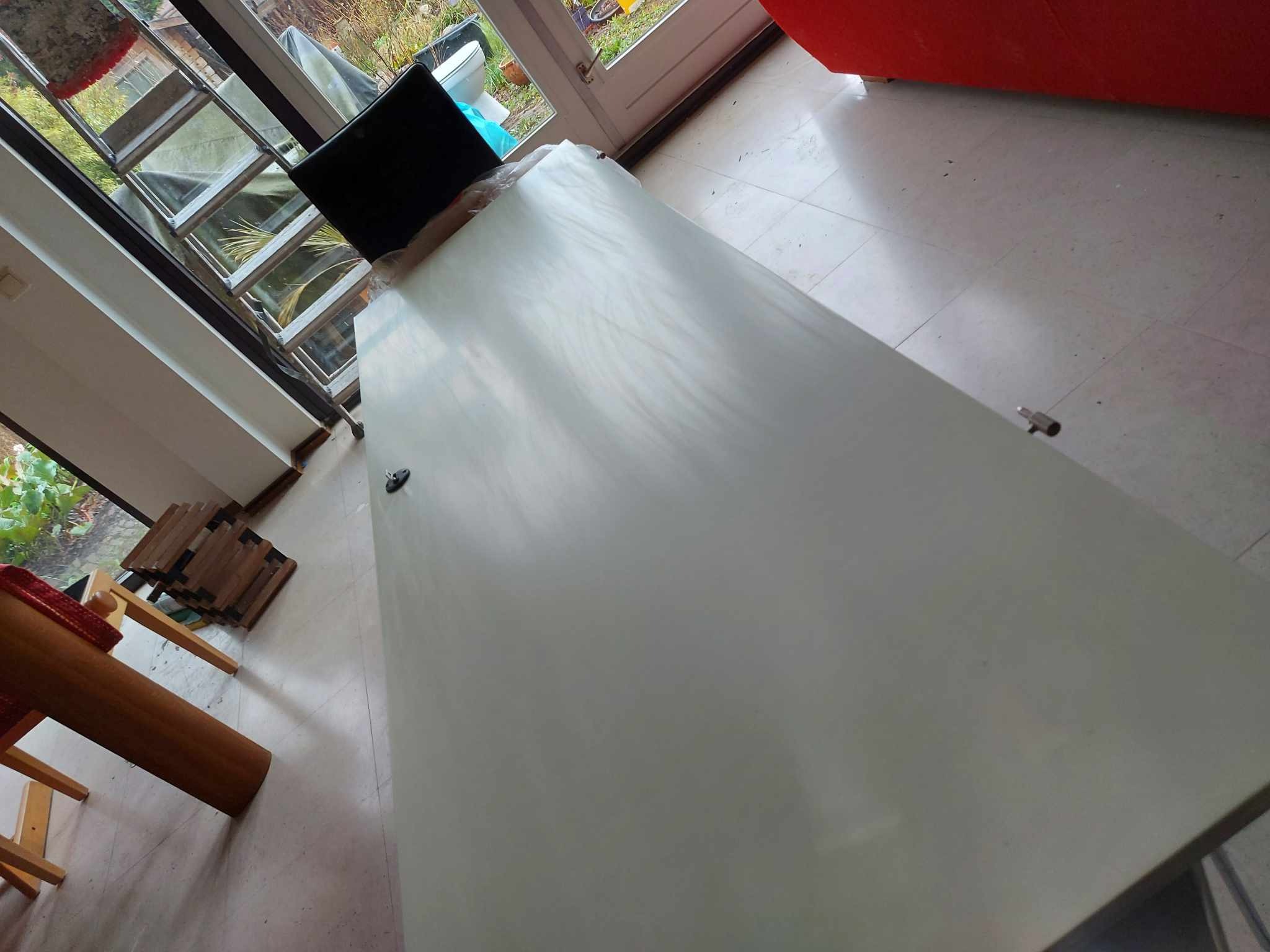 Świeżo pomalowana, jasna powierzchnia ściany w pomieszczeniu z widocznymi elementami wyposażenia i oknem.